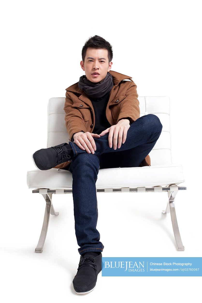 Stylish young Chinese man sitting on a chair