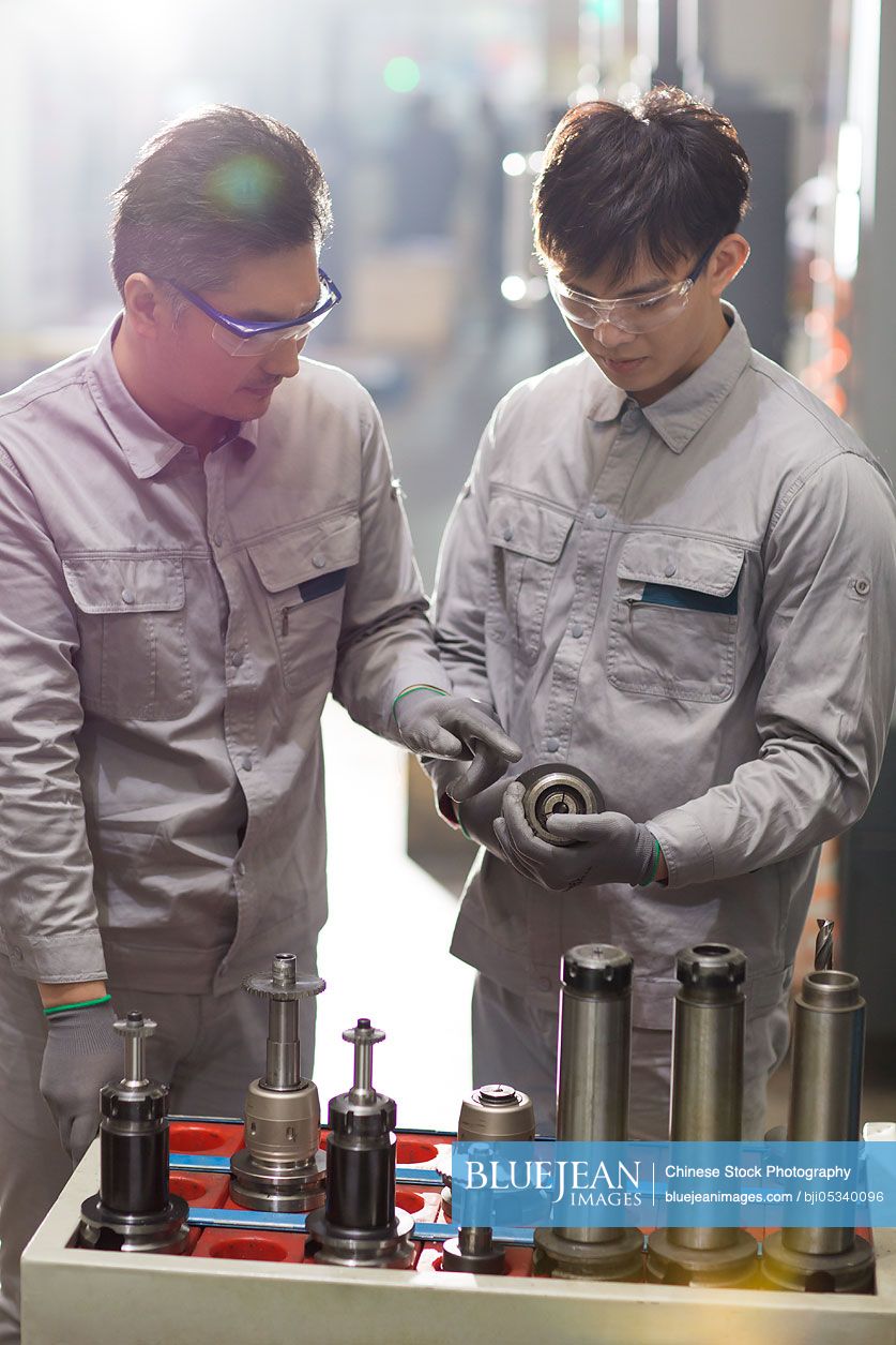 Confident Chinese engineers working in the factory