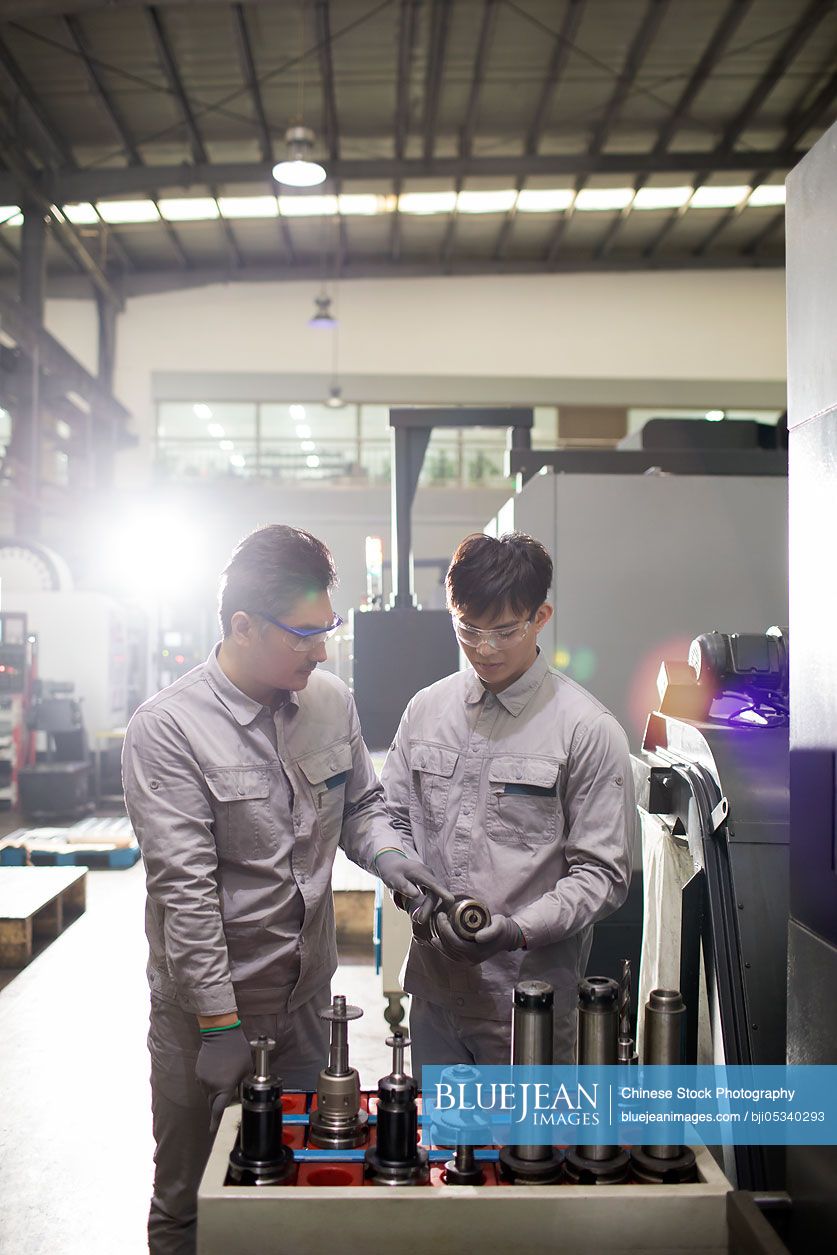 Confident Chinese engineers working in the factory