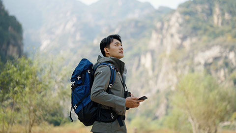 Young Chinese man hiking outdoors