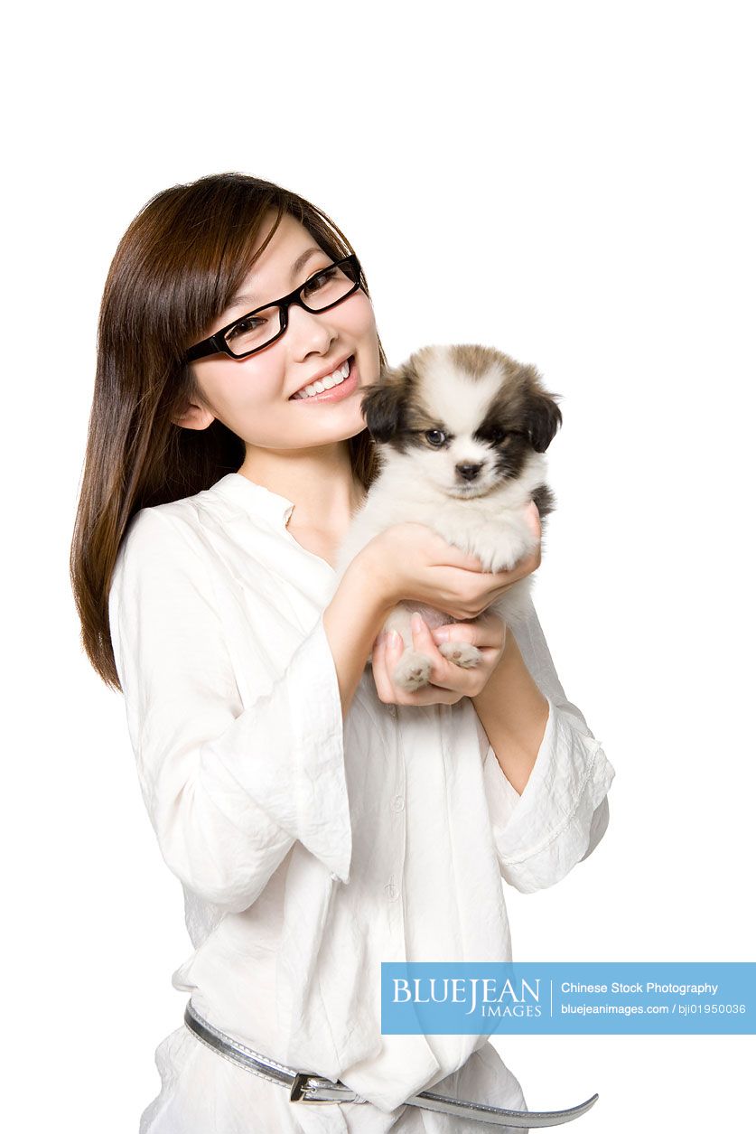 Portrait of young Chinese woman with Shih Tzu puppy