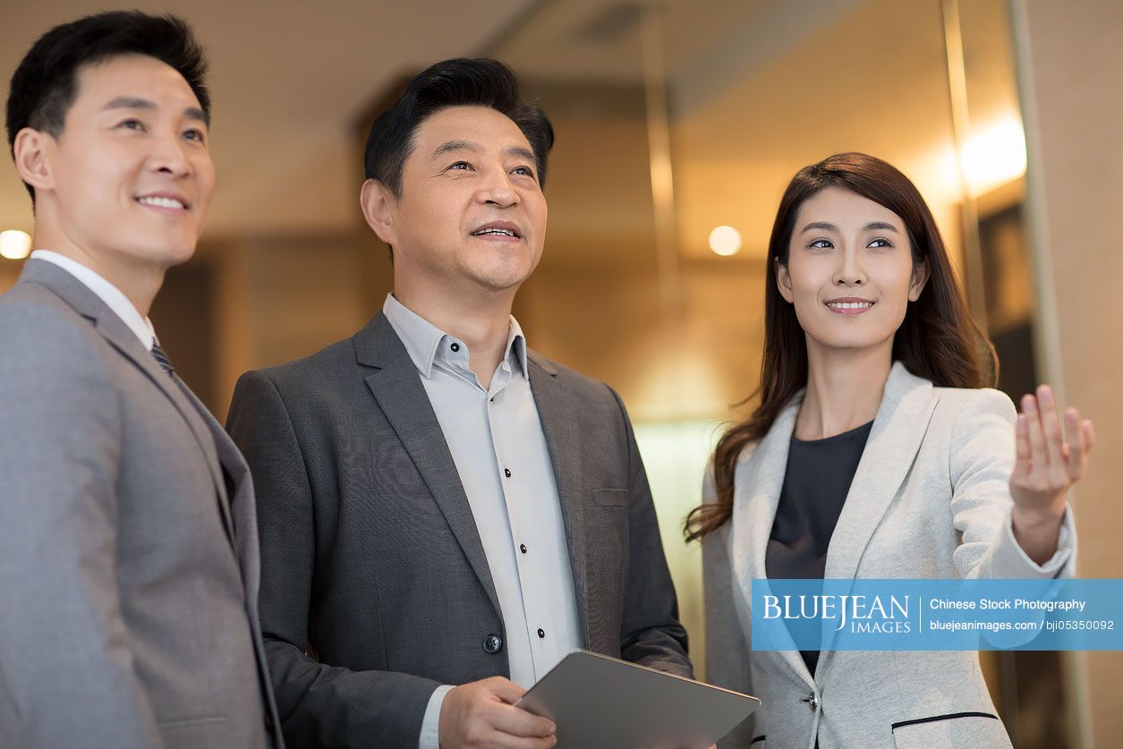 Cheerful Chinese business people talking indoors