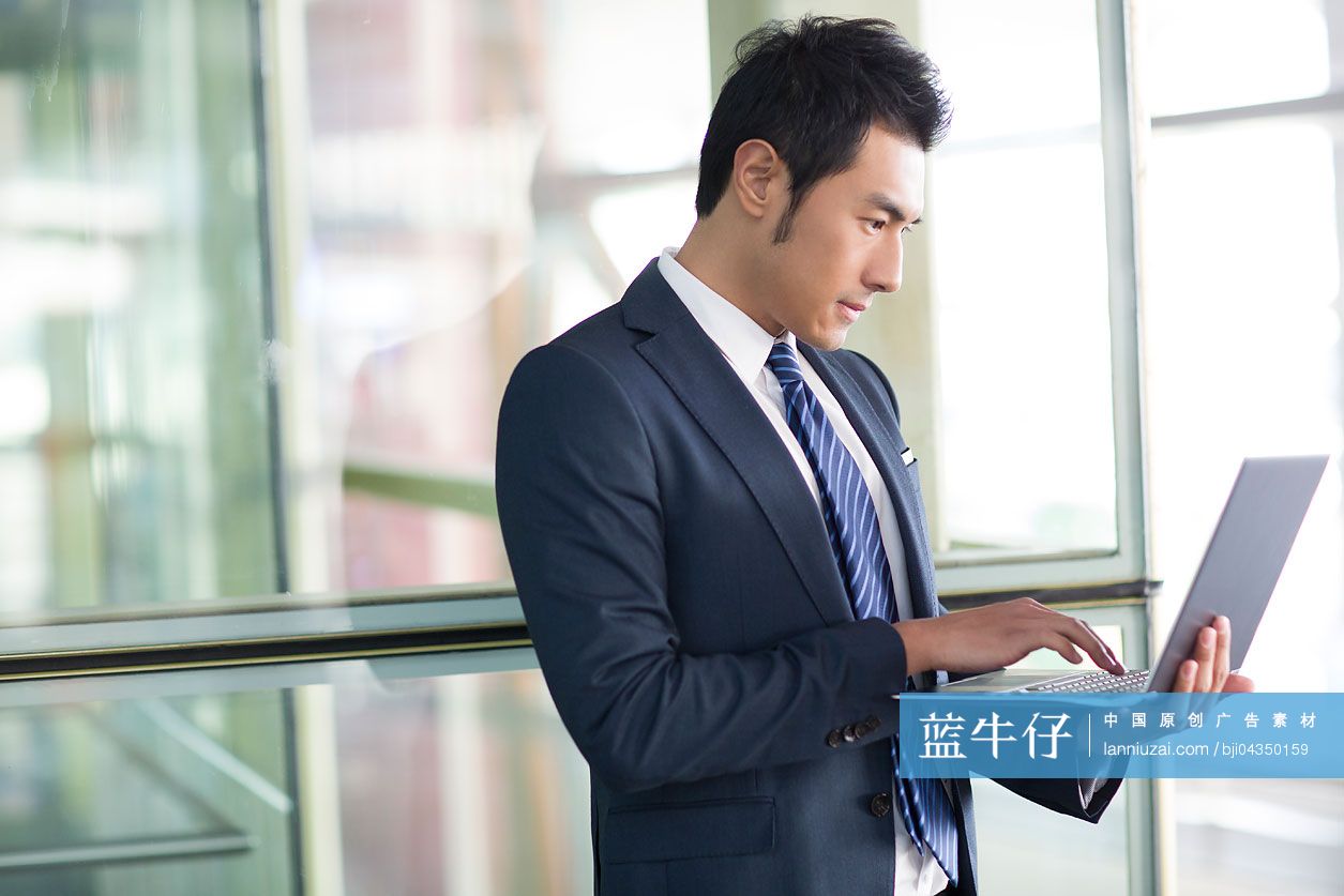 年轻商务男士在机场使用笔记本电脑
