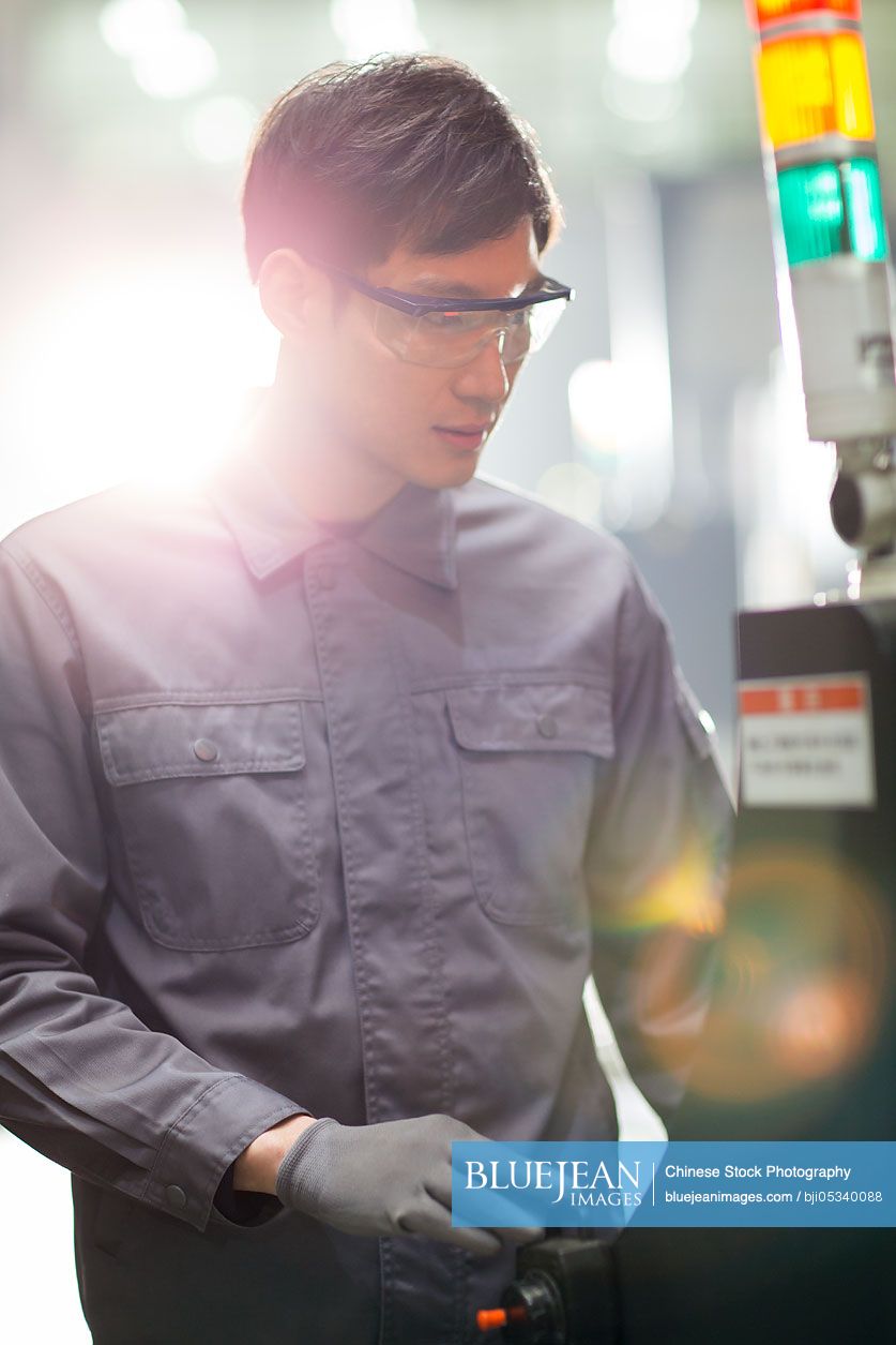 Young Chinese engineer working in the factory