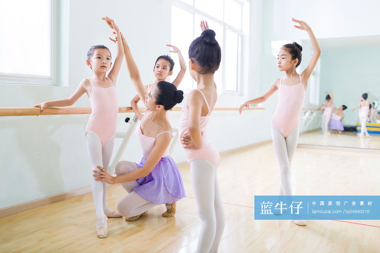 年轻舞蹈老师教小女孩们跳芭蕾