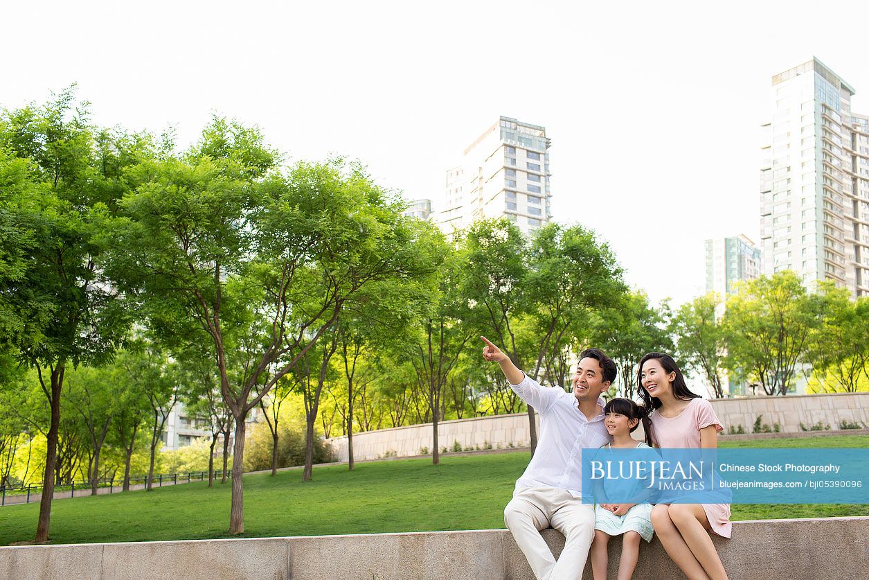 Happy young Chinese family looking at view