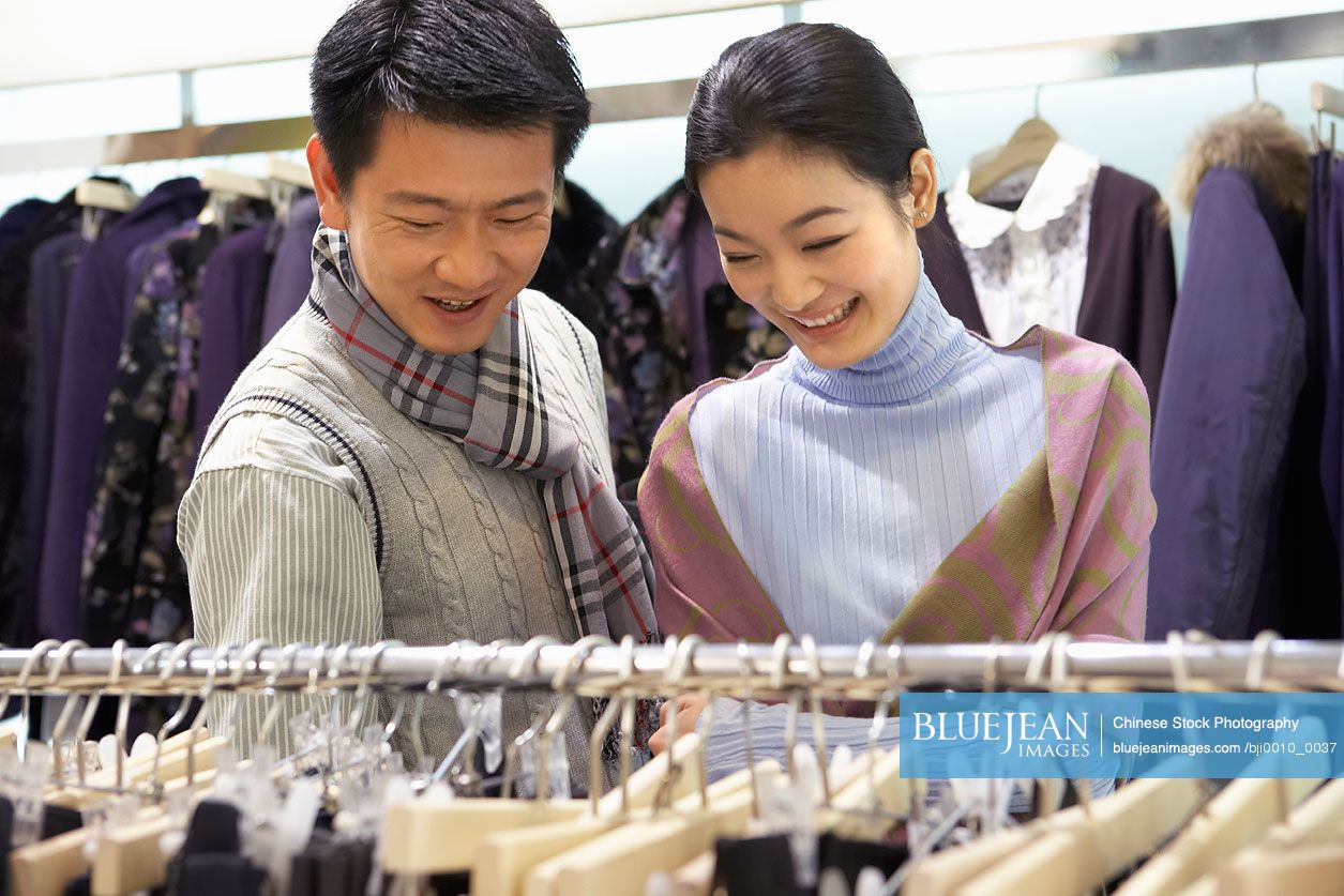 Chinese couple looking at clothes in store