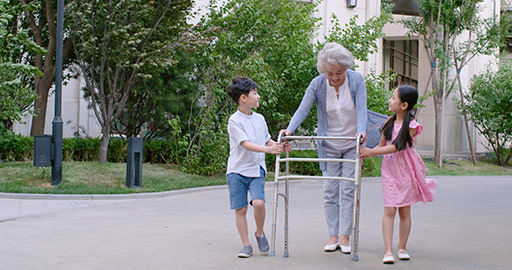 Happy Chinese sibling helping grandmother walking with walking frame,4K