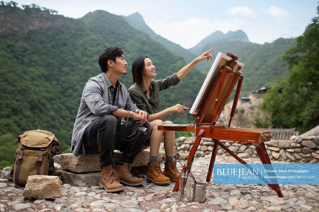 Young Chinese couple painting outdoors