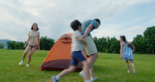 Happy young Chinese family camping outdoors,4K