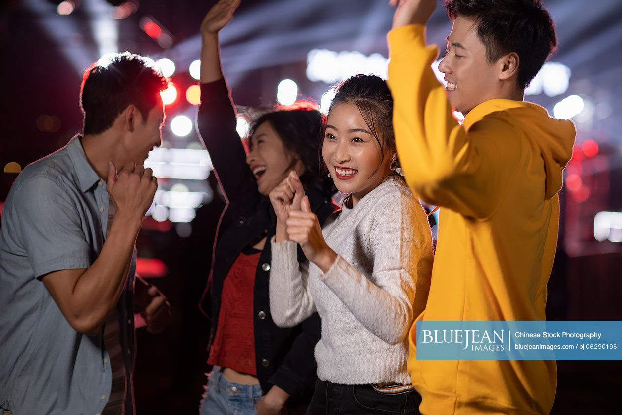 Happy young Chinese friends having fun at music festival