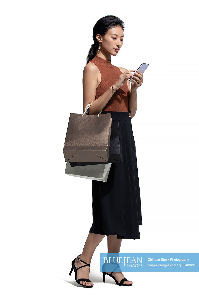Cheerful young Chinese woman shopping