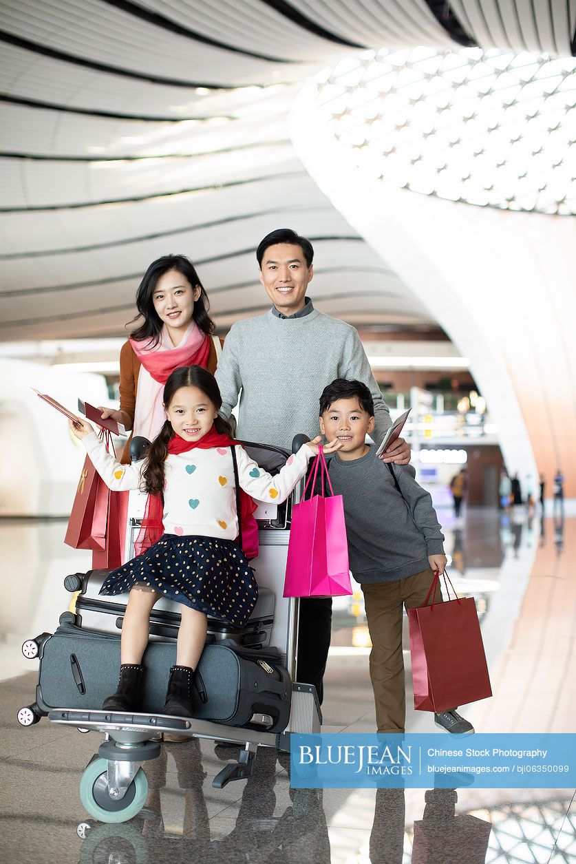 Happy young Chinese family travelling from airport