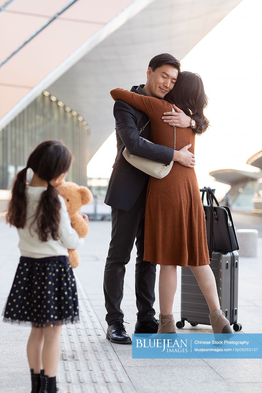 Happy young Chinese family at airport
