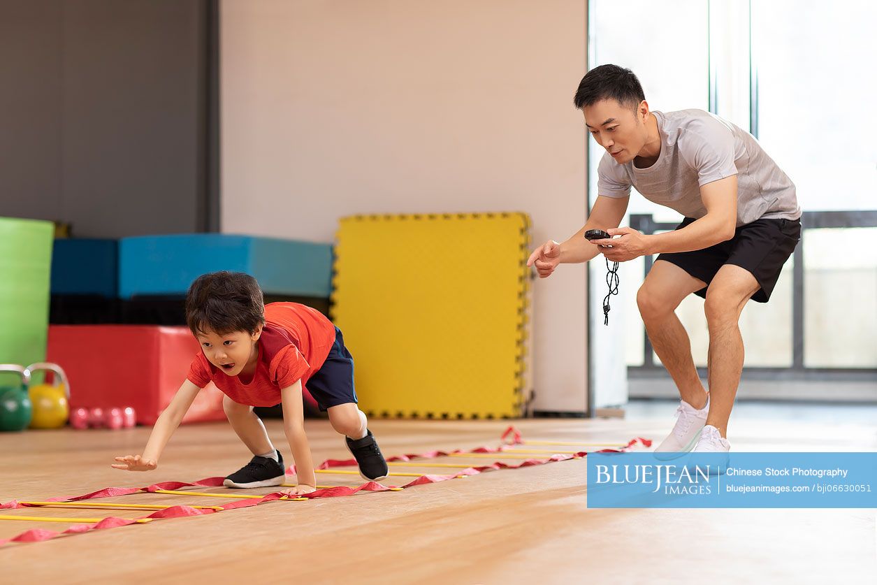 Little Chinese boy having exercise class in gym