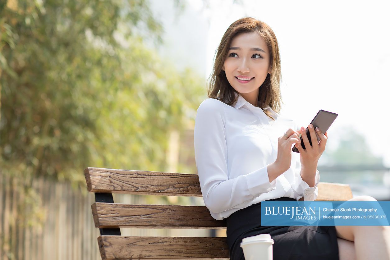 Young Chinese businesswoman holding a smart phone