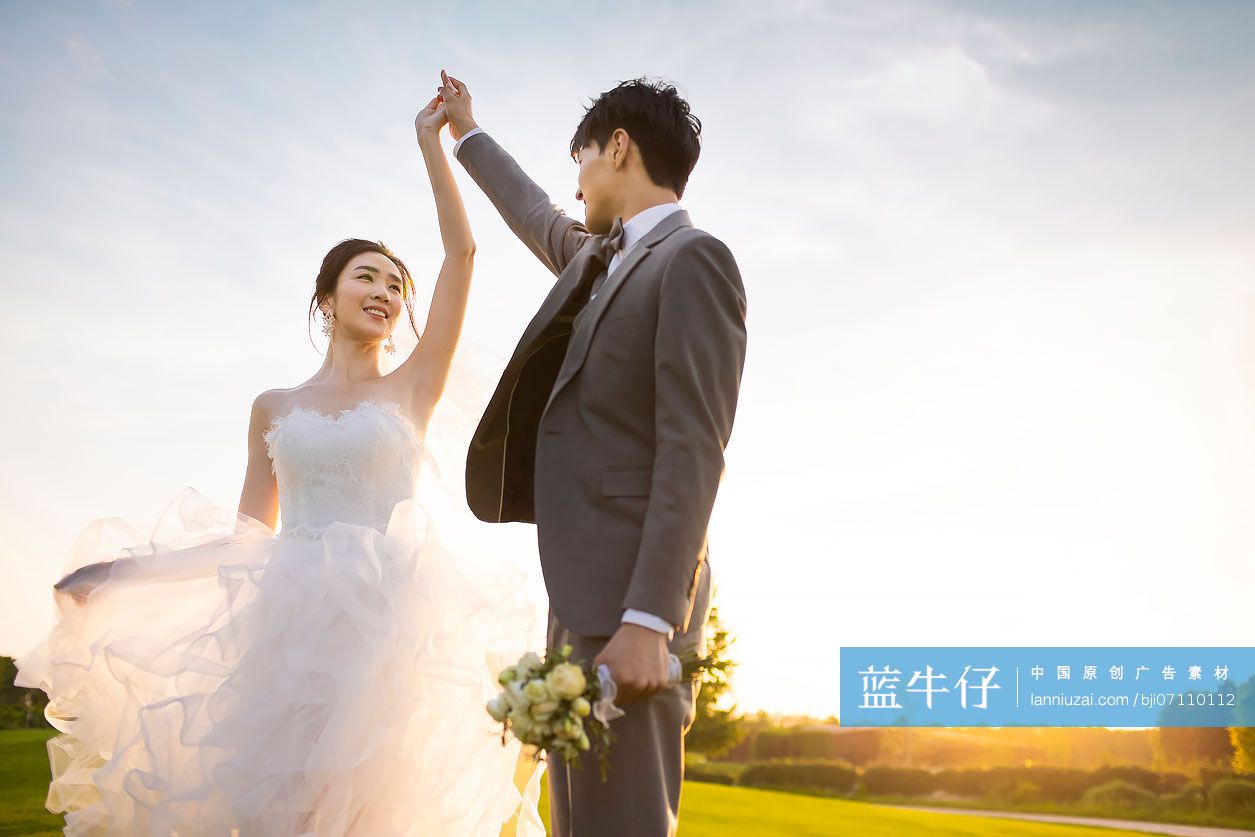 快乐的新郎新娘在草地上跳舞