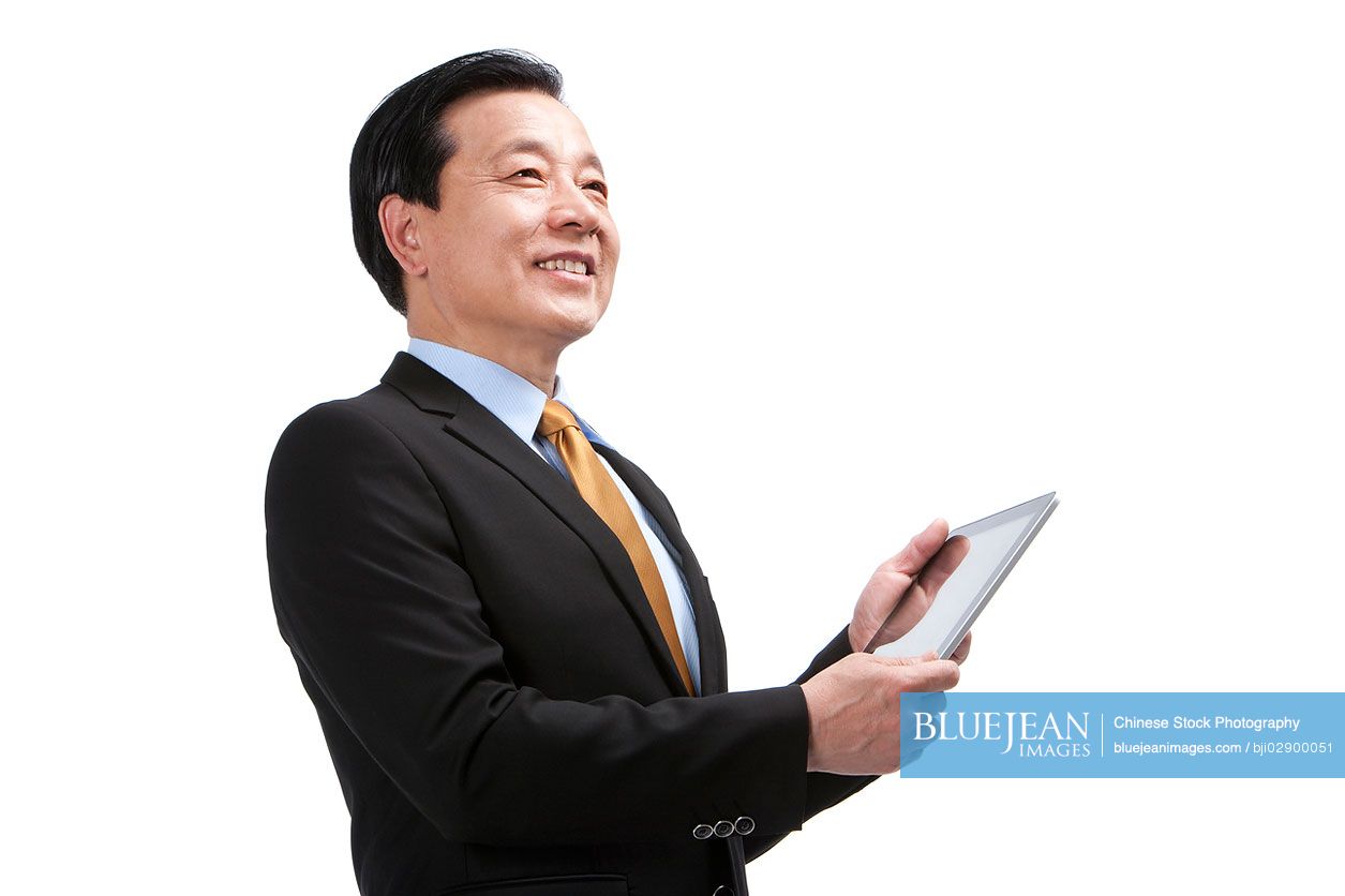 Chinese Senior Chinese businessman using digital tablet
