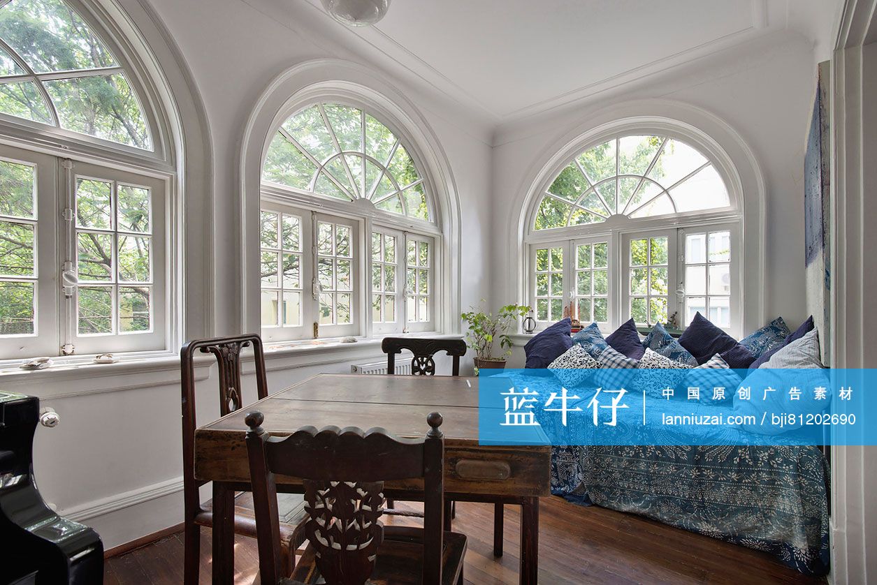 Large windows with chairs around wooden table in foreground at bedroom