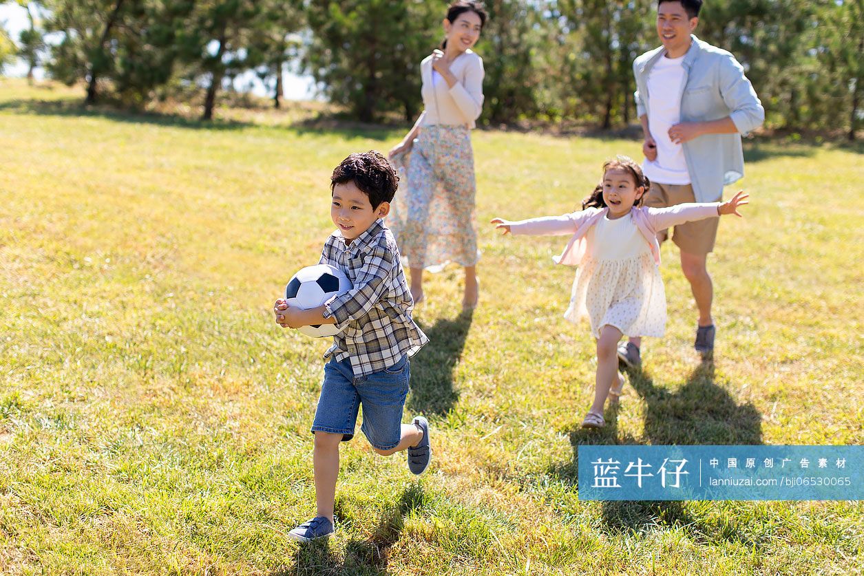 快乐的年轻家庭在草地上玩耍