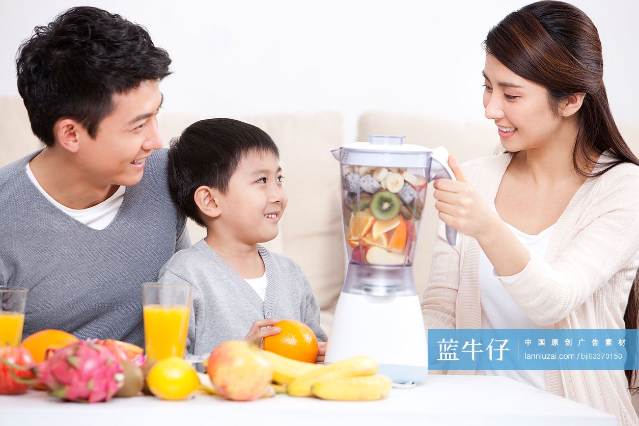 开心的一家人使用榨汁机做果汁