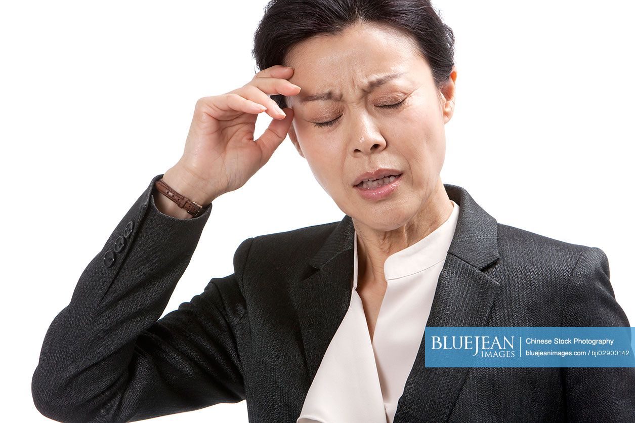 Middle-aged Chinese businesswoman suffering from headache