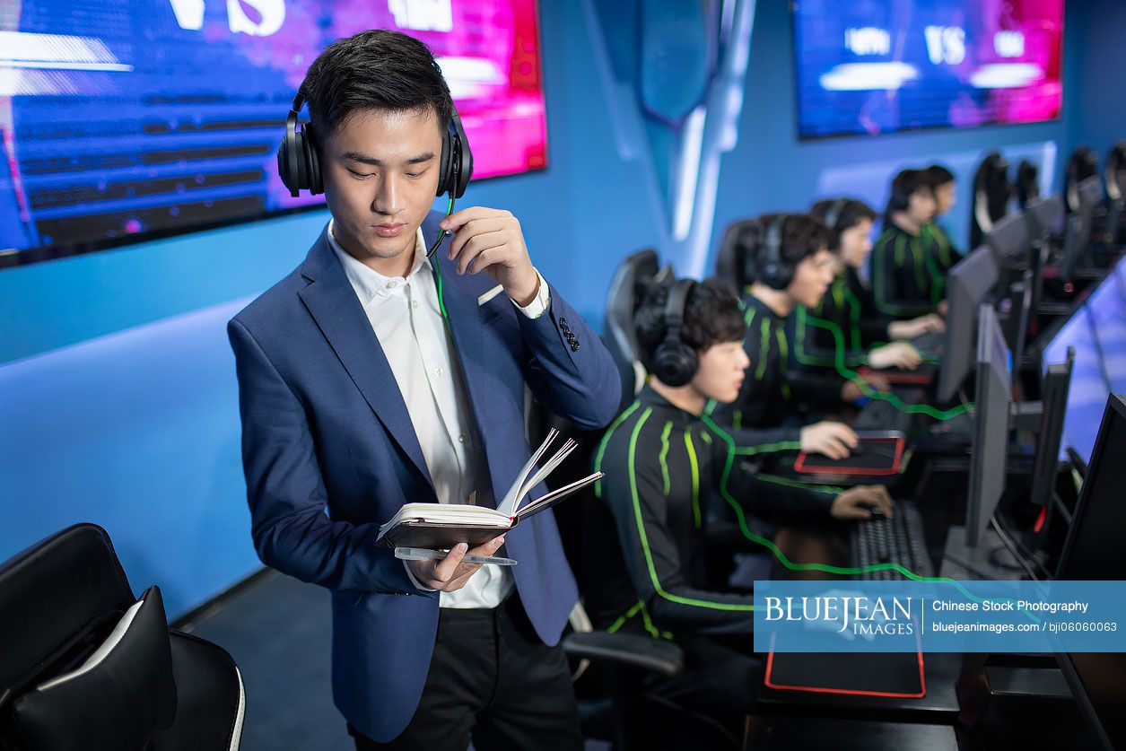 Young Chinese man coaching gamer playing esports
