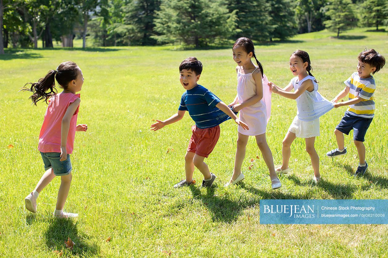 Happy Chinese children playing games on meadow