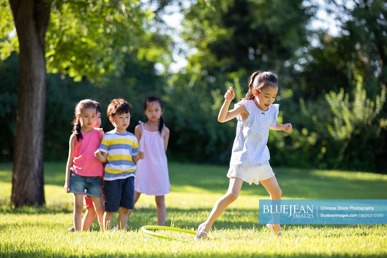Happy Chinese children playing on meadow