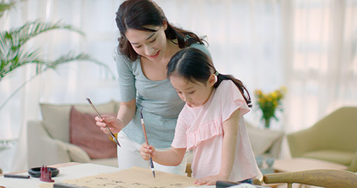 Happy Chinese mother and daughter writing calligraphy at home,4K