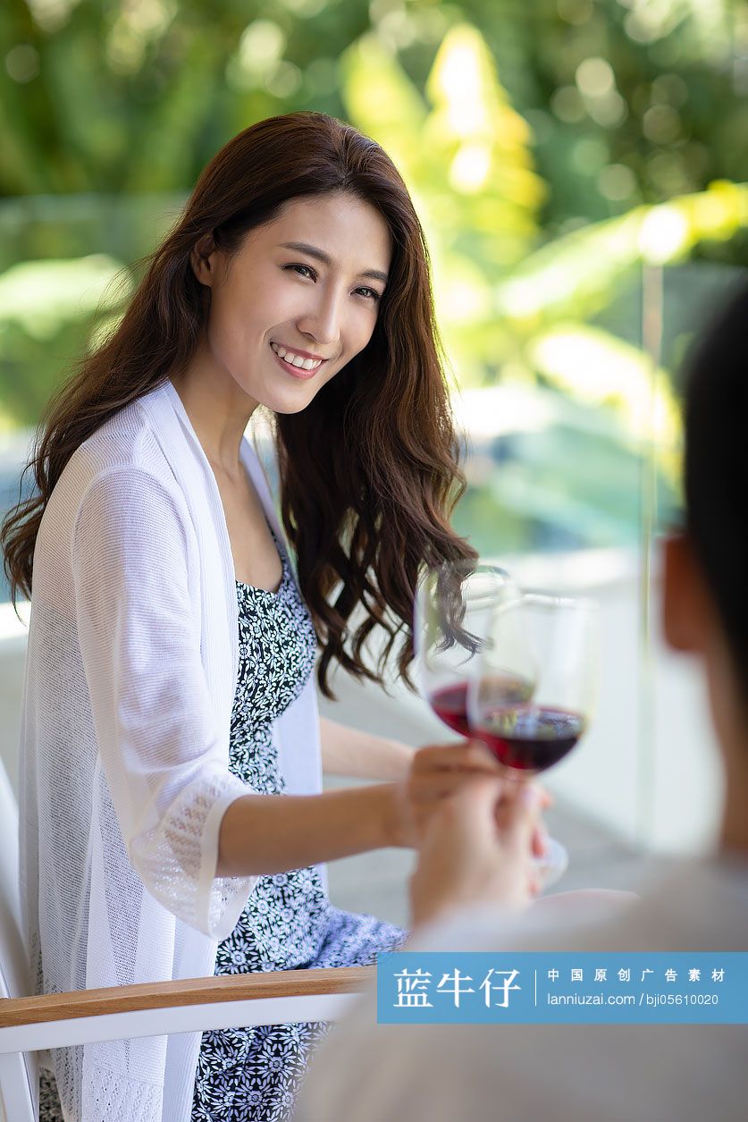 年轻夫妇在露台喝红酒