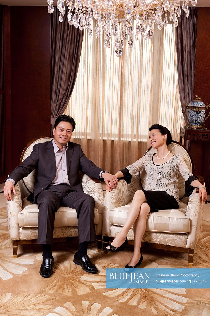 Senior Chinese couple sitting in a luxurious room