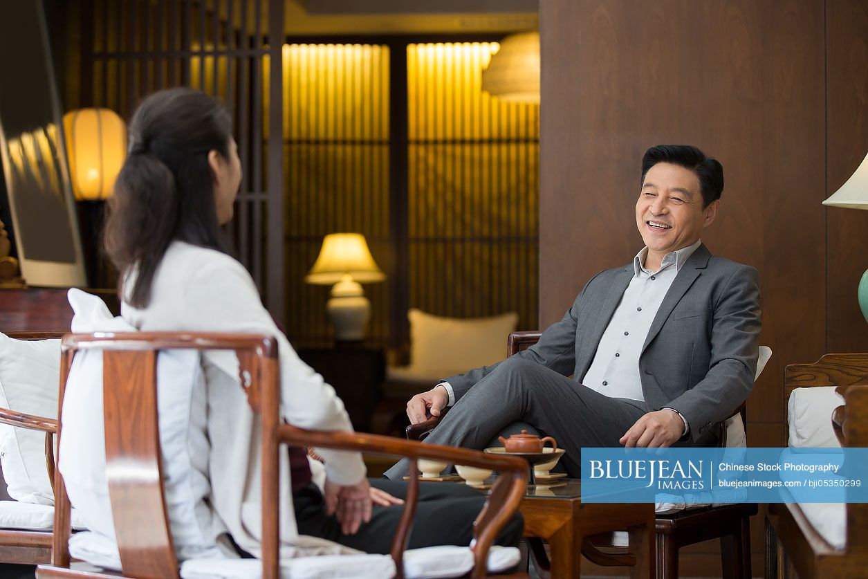 Cheerful Chinese businessman talking with a woman