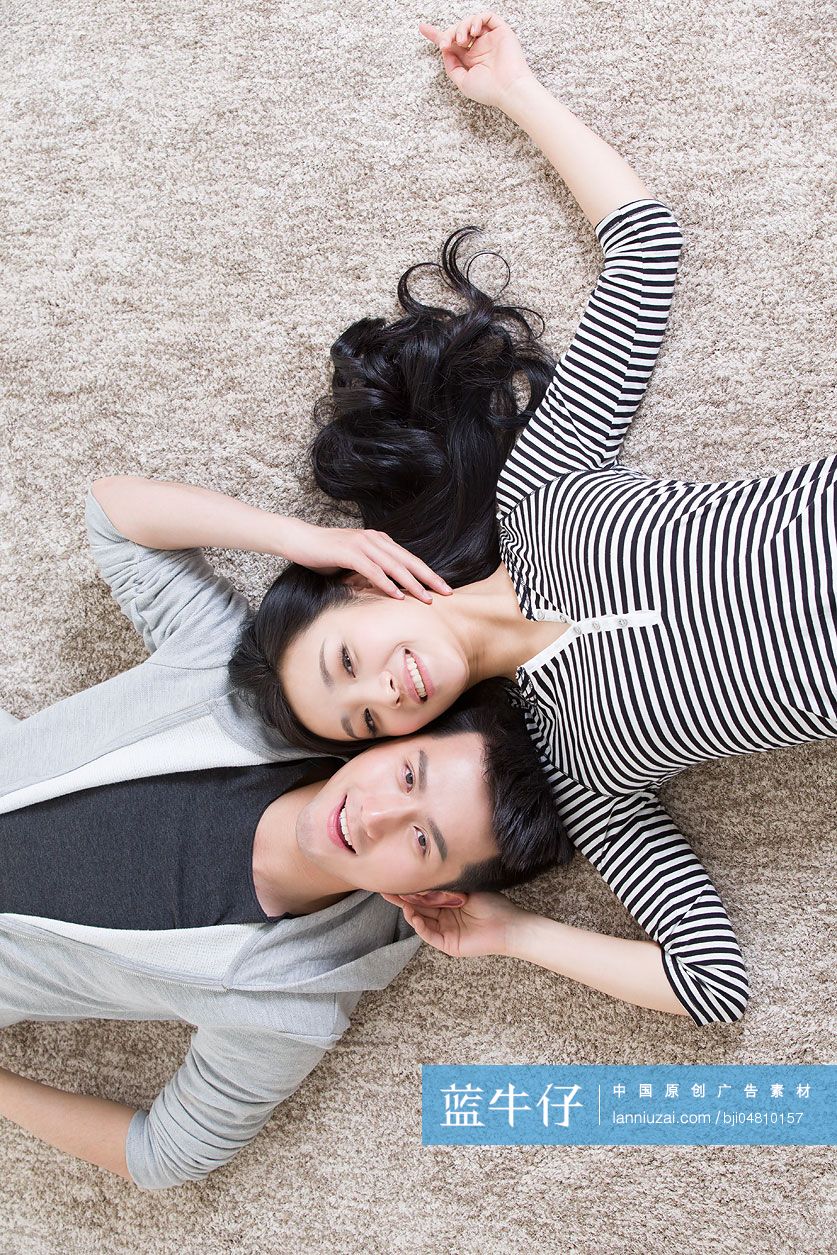 年轻情侣躺在地毯上