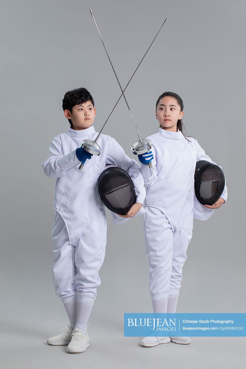 Cute Chinese girl and boy in fencing suit
