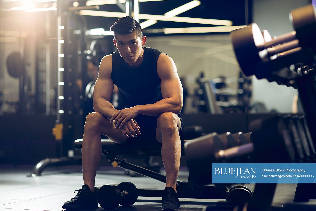 Young Chinese man exercising at gym