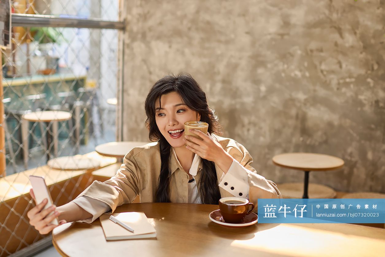 快乐年轻女性在咖啡馆自拍