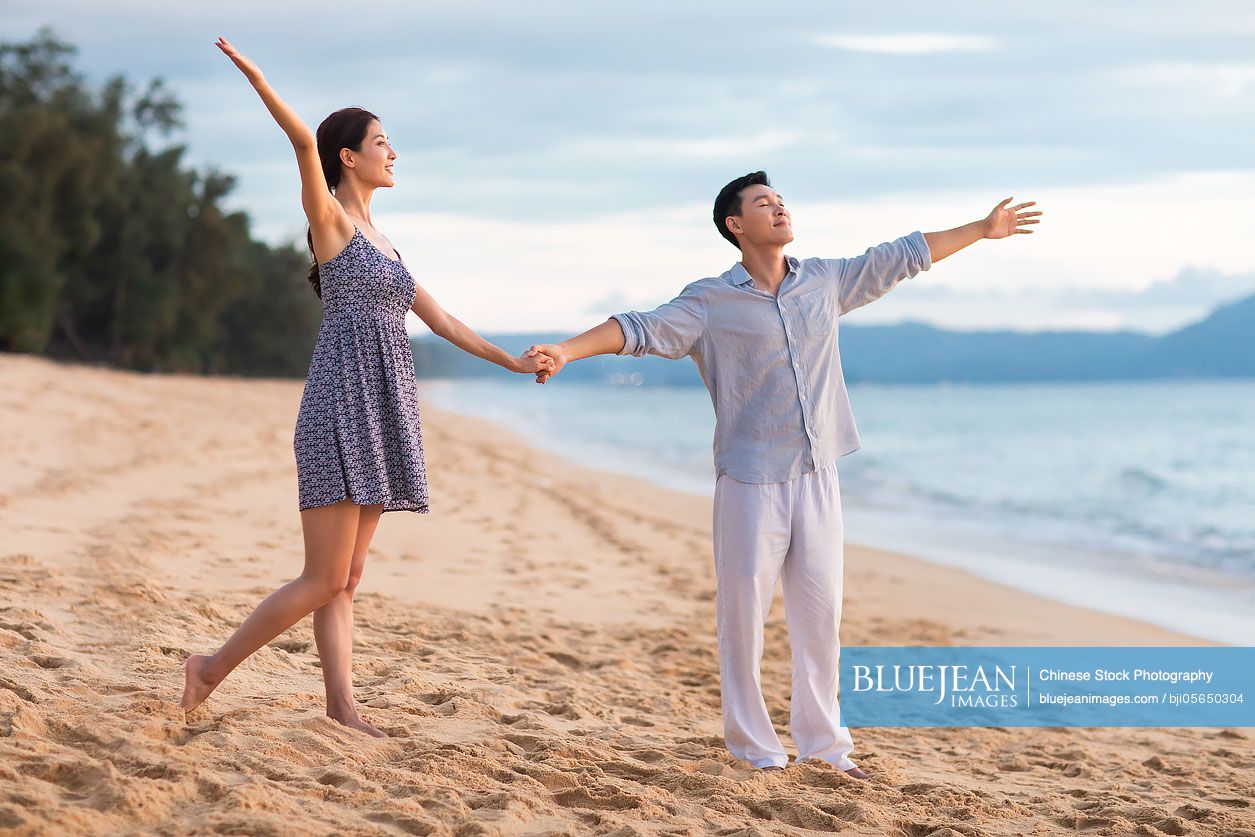 Happy young Chinese couple on beach