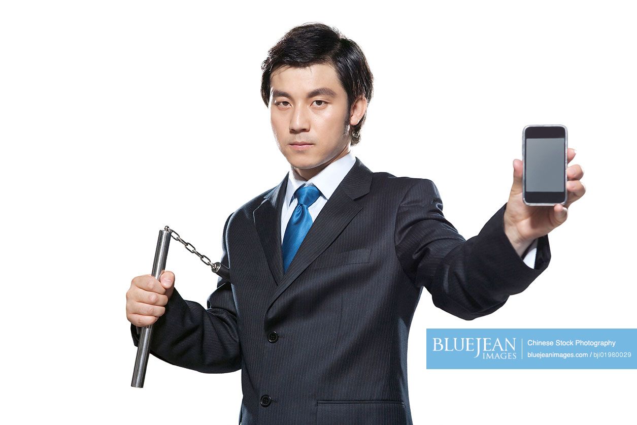 Chinese businessman holding nunchukus and cellphone