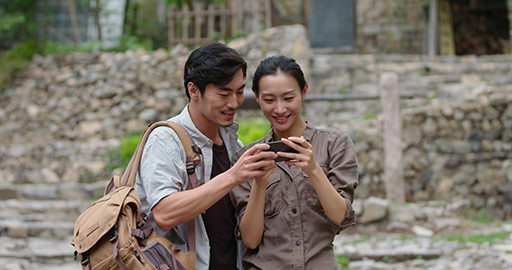 Young Chinese couple using smartphone outdoors,4K