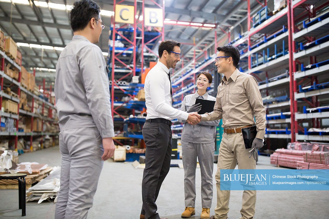 Businessman shaking hands with engineer in the factory