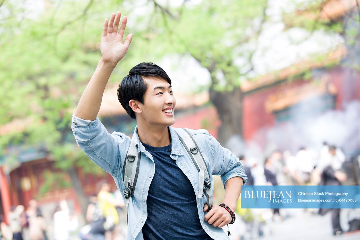 Young Chinese man waving
