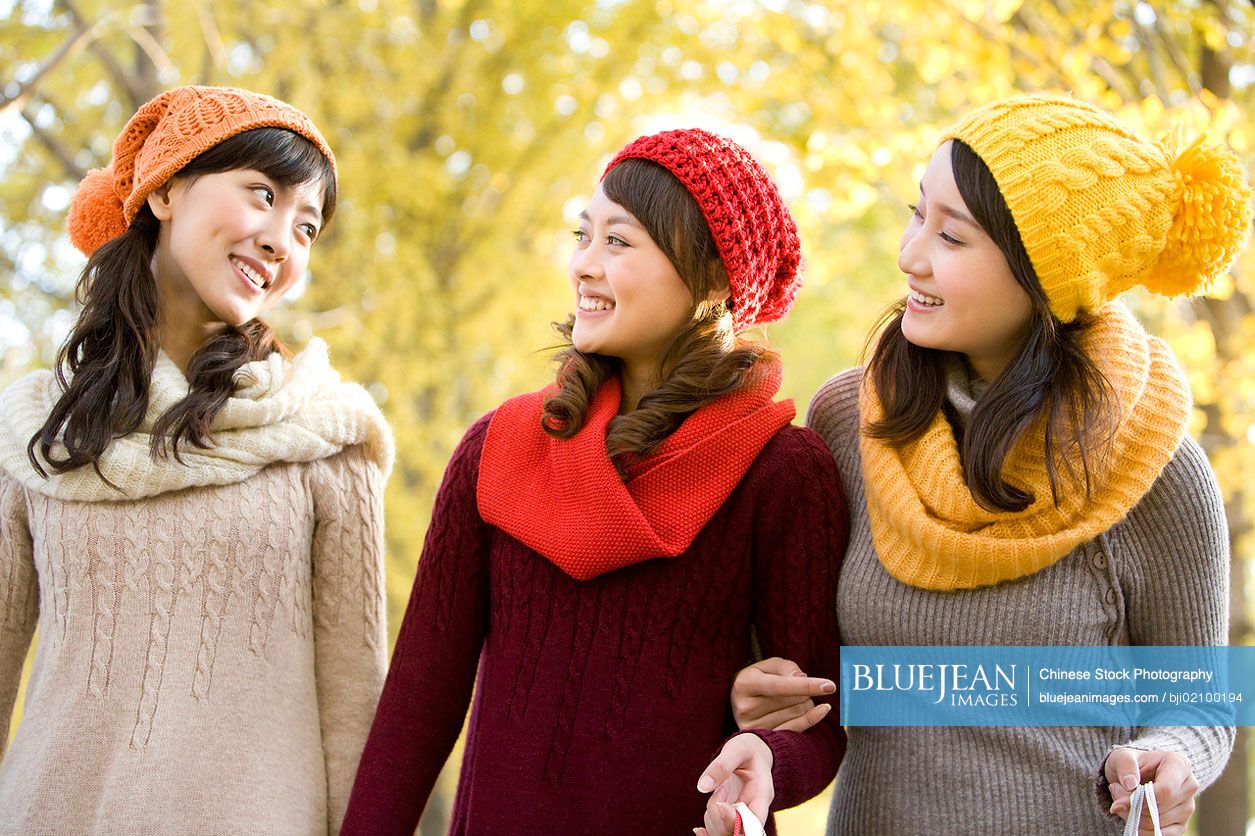 Young Chinese female friends in a park with shopping bags