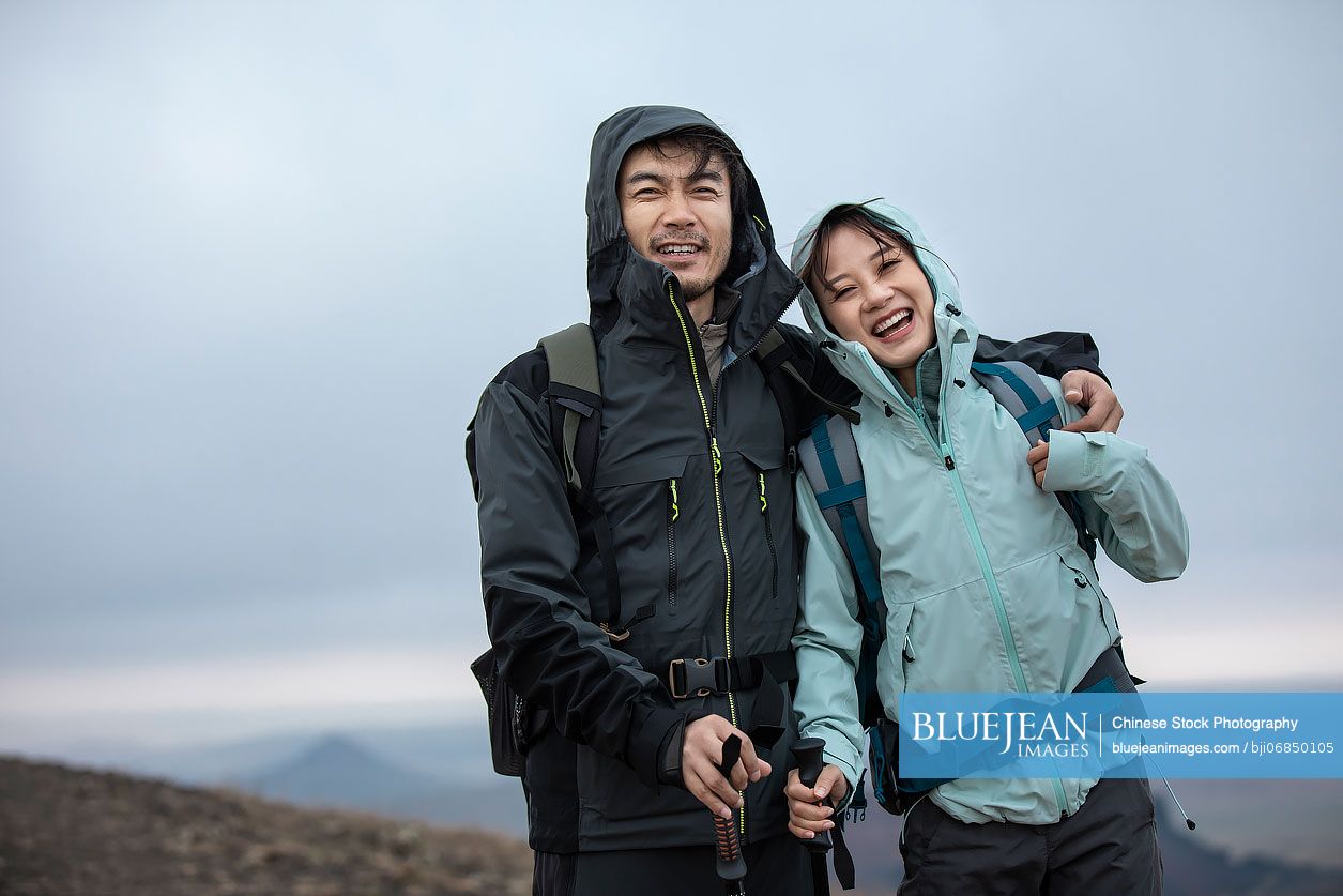 Happy Chinese couple hiking outdoors