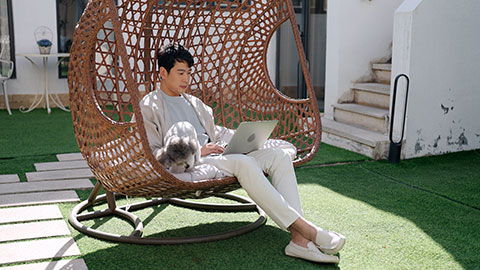 Happy mid adult Chinese man using laptop on hanging-chair,4K