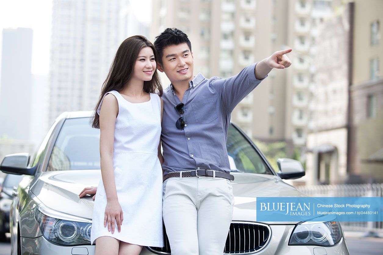 Happy young Chinese couple and car