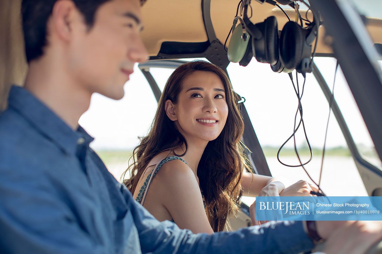 Happy young Chinese couple on a helicopter