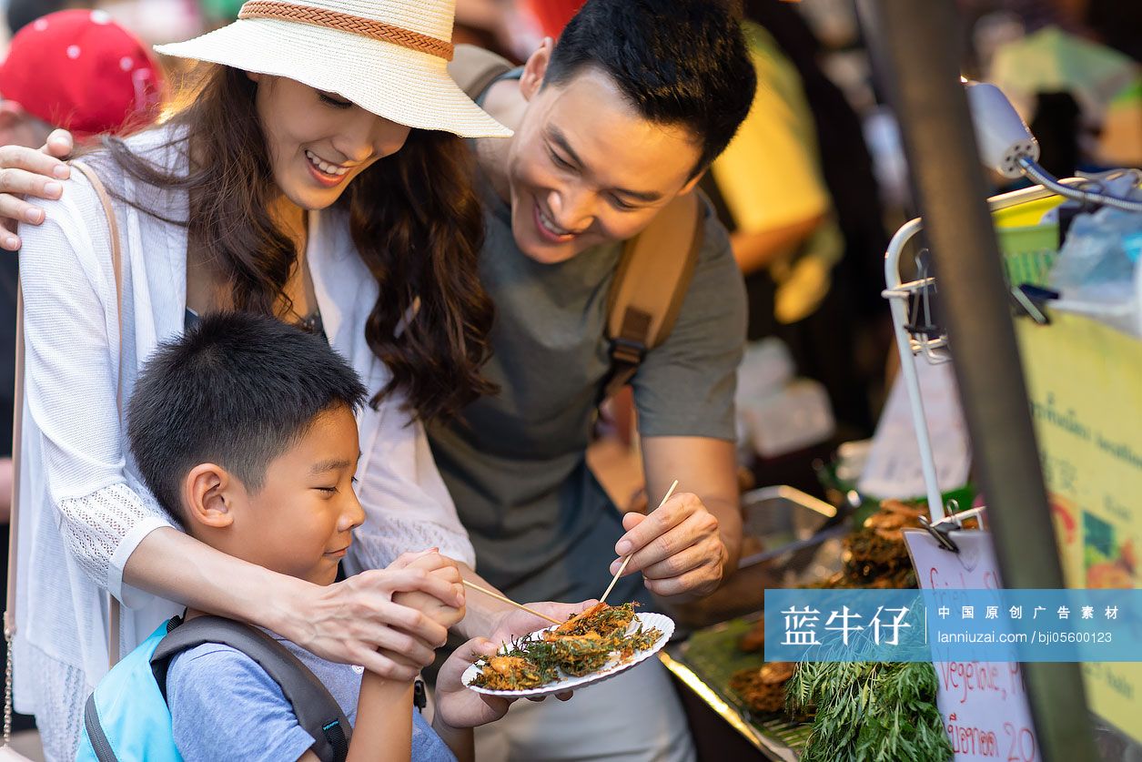 快乐的年轻家庭在街头品尝美食