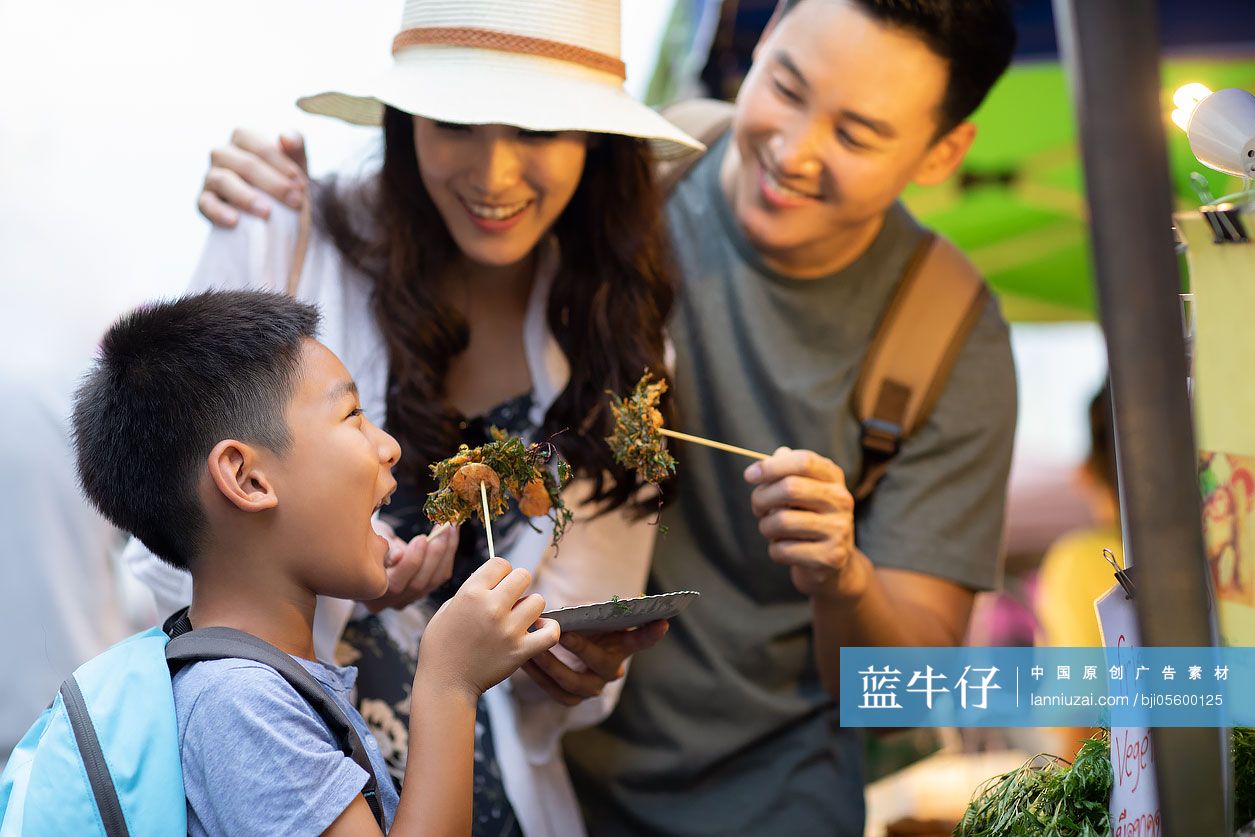 快乐的年轻家庭在街头品尝美食