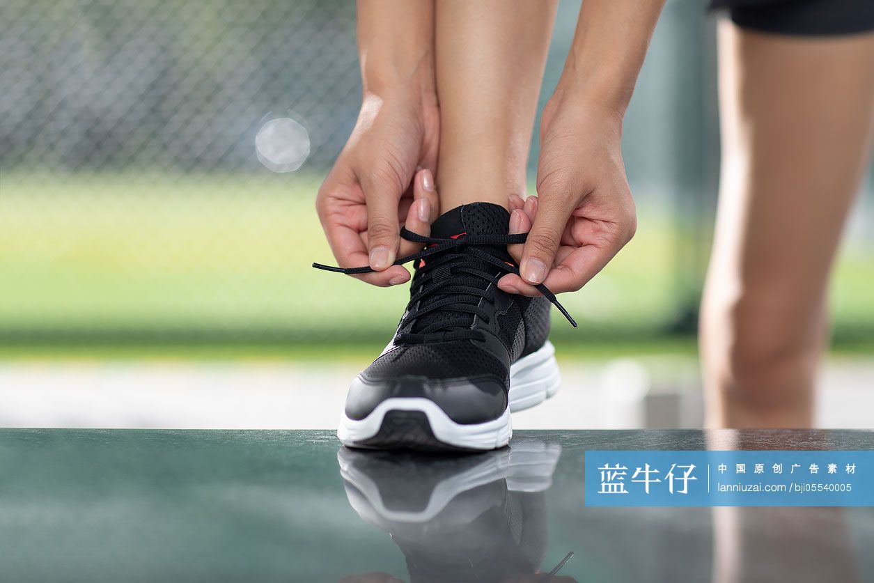 年轻女士跑步前系鞋带